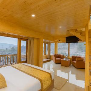 Un dormitorio con una cama grande y un balcón. en Himalayan Fort Resort, Manali - !! Riverside Property !! Big Garden with Campfire !! Guest Preferred !! Scenic River & Mountain View !! Big Parking !! Luxury Balcony Rooms !! Playing Zone !! Property of the Year, en Manali