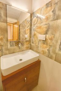 un baño con lavabo y espejo en Himalayan Fort Resort, Manali - !! Riverside Property !! Big Garden with Campfire !! Guest Preferred !! Scenic River & Mountain View !! Big Parking !! Luxury Balcony Rooms !! Playing Zone !! Property of the Year, en Manali