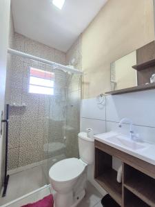 a bathroom with a toilet and a shower and a sink at Residencial Via Mar - Massaguaçu in Caraguatatuba
