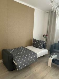 niewielka sypialnia z łóżkiem i niebieską kanapą w obiekcie Apartment 1 w mieście Gera