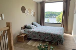 Ένα ή περισσότερα κρεβάτια σε δωμάτιο στο Les Terrasses du Lac - Vu sur le lac - 500m de la plage de fougères