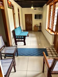 sala de estar con silla azul y alfombra en Kodiyadans Kooh, en Meenangadi