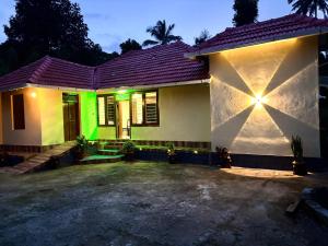 una casa con luz verde delante de ella en Kodiyadans Kooh, en Meenangadi 8 fotos más