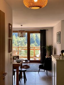 a living room with a table and a large window at Les Lucioles - Charming flat in the mountains in Saint-Jean-de-Sixt