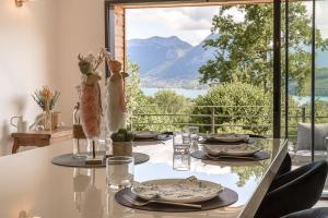 Una mesa de comedor con vista a una montaña. en Villa Panoramiqua - Vue 180 sur le Lac d'Annecy et les montagnes, en Saint-Jorioz