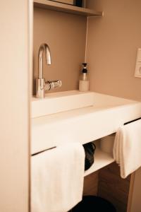 a bathroom with a sink and towels on a shelf at Das HOB - Hotel Original Bamberg in Bamberg