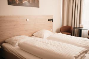 a bed in a hotel room with a white bedspread at Das HOB - Hotel Original Bamberg in Bamberg