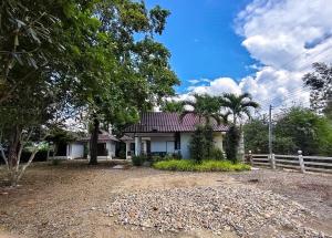 a white house with a fence and palm trees at A-Thip House in Pai