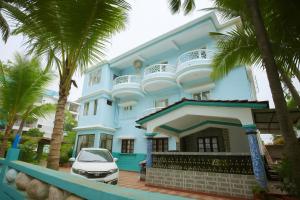 a blue house with a car parked in front of it at Mottel AC Room with Breakfast at Calangute in Calangute