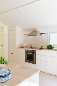 Una cocina con gabinetes blancos y una estufa. en Villa Ortensa, en Soorts-Hossegor