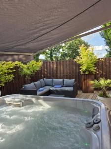 a jacuzzi tub in a backyard with a couch at Le Rêve de Narcisse in Fléron