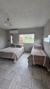 ein Schlafzimmer mit zwei Betten und einem großen Fenster in der Unterkunft Verano pleno in Monte Hermoso