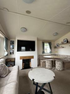a living room with a couch and a table at Two Bedroom Caravan on 7 Lakes Country Park in Crowle