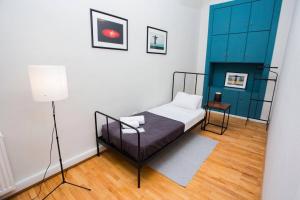 1 dormitorio con 1 cama y armario azul en Charming 2BR Apartment In Old Tbilisi - By Wehost, en Tiflis