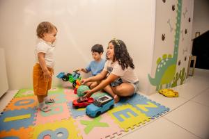 a group of children playing with toys on a rug at Go Inn Hotel Aracaju in Aracaju