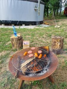 a grill with meat and oranges on it in a field at 01 JURTA šedá u stodoly  +113 photos
