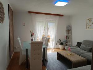 ein Wohnzimmer mit einem Tisch und einem Sofa in der Unterkunft Ella Ferienwohnung in Arnoldstein