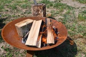 a wooden table with a fire on a stump at 01 JURTA šedá u stodoly in Chotětice +46 photos