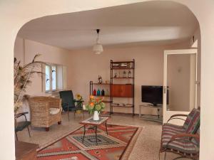 Una sala de estar con una mesa y un televisor. en Family House on private courtyard in Fanna, en Fanna