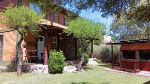a brick house with trees in the yard at Cabañas Lo de Alberto in Santa Rosa de Calamuchita +15 photos