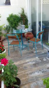 einen Tisch und zwei Stühle auf einer Veranda mit Pflanzen in der Unterkunft Tel Aviv Roof Apartment in Tel Aviv