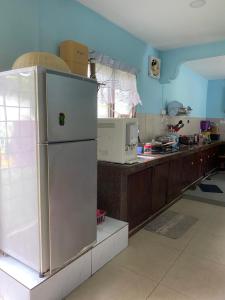 a kitchen with a white refrigerator and a counter at ANA Homestay in Hulu Langat