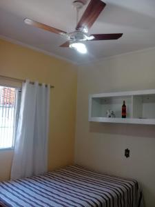 a bedroom with a ceiling fan and a bed at Casa para temporada - Martin de Sá in Caraguatatuba