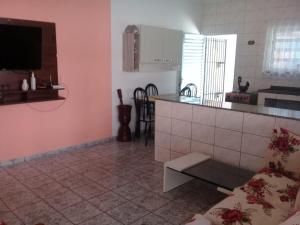 a kitchen with pink walls and a counter top at Casa para temporada - Martin de Sá in Caraguatatuba +4 photos