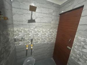 a bathroom with a toilet and a stone wall at RC Stays in Noida +17 photos