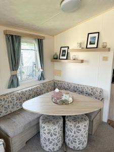 a living room with a table and a couch at Two Bedroom Caravan on 7 Lakes Country Park in Crowle