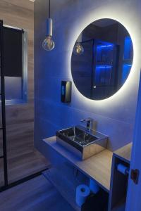 un bagno blu con un lavandino e uno specchio di Cuencaloft Ático Encantado Deluxe con Terraza a Cuenca