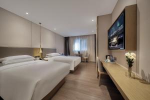 Ένα ή περισσότερα κρεβάτια σε δωμάτιο στο Echarm Hotel Guangzhou Gangding Huashi Subway Station Tianhe North Branch