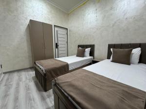 a bedroom with two beds and a closet with a door at Art Home in Tashkent