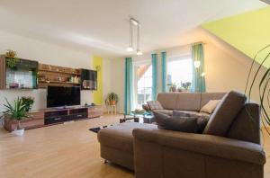 a living room with a couch and a television at Ferienwohnung Lahner in Königsfeld