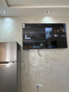 a flat screen tv hanging on a wall next to a refrigerator at Studio Riviera in Tangier