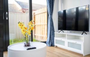 a living room with a tv and a vase of flowers on a table at Haven Home Ringwood Wilana in Ringwood