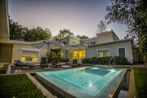 a swimming pool in front of a house at Joan Miró Hotel in Punta del Este