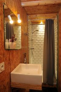 Un baño con un lavabo blanco y un espejo. en La Grange, en Sablet