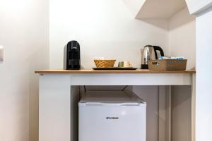 a kitchen with a counter and a refrigerator under a table at Suite Le Cementine in Mottola +14 photos