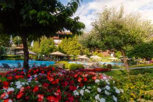 un jardín con flores frente a una piscina en Hotel Alpestre, en Gramado 124 fotos más