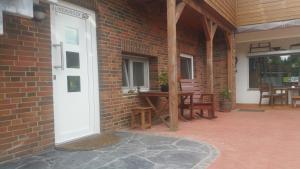 a brick building with a white door and a patio at Elbe-Ferien 2 in Tespe