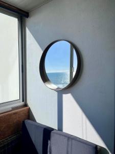 a round mirror in a room with a window at Oasis Tropical Sauna Privé Vue Mer & Plage À 100M in Saint-Hilaire-de-Riez +24 photos