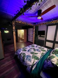 a bed in a room with a purple ceiling at Oasis Tropical Sauna Privé Vue Mer & Plage À 100M in Saint-Hilaire-de-Riez