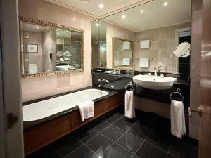 a large bathroom with a tub and a sink at Royal Majestic Hotel in Johannesburg