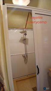 een douche in een badkamer met een glazen deur bij Layalée Luxurycamp in Merzouga +98 foto's