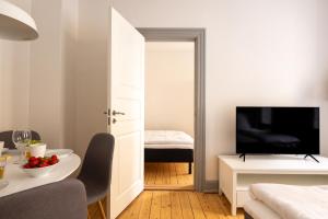 a living room with a television and a room with a table at Authentic Copenhagen Apartment for 4 Guests in Copenhagen