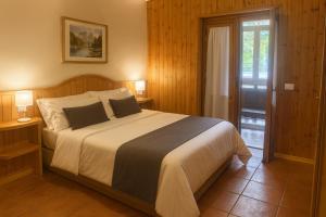 a bedroom with a large bed with two lamps at Chalet Mary Roccaraso in Roccaraso