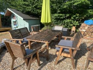a wooden table and chairs with a yellow umbrella at The Cabin at Box Cottage in Somerton