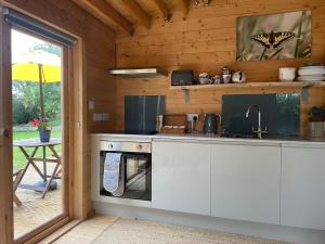 a kitchen with a stove and a sink in a cabin at The Cabin at Box Cottage in Somerton