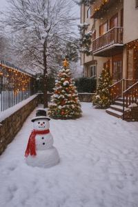 a snowman and two christmas trees in the snow at Chalet Mary Roccaraso in Roccaraso